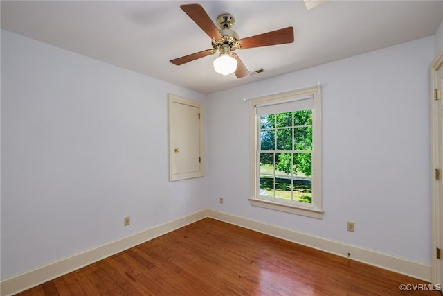 empty room featuring a ceiling fan, baseboards, and hardwood / wood-style flooring