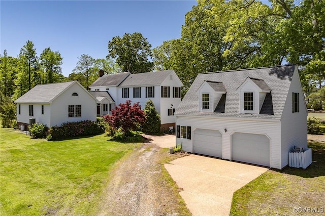 view of front of property featuring roof with shingles, driveway, and a front yard