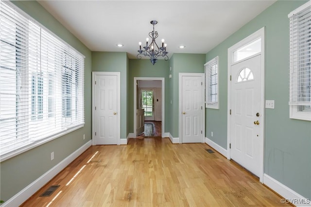 foyer featuring visible vents, baseboards, light wood-type flooring, recessed lighting, and a notable chandelier