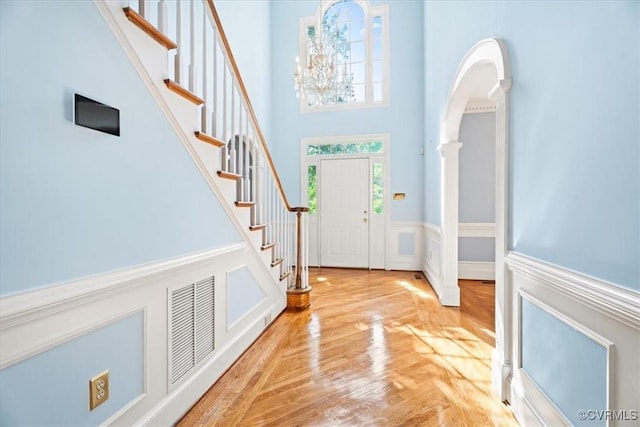 419 Dellbrooks Pl, Henrico, VA 23238 - foyer entrance with stairs, a high ceiling, arched walkways, wood finished floors, and wainscoting