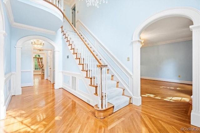 419 Dellbrooks Pl, Henrico, VA 23238 - stairs featuring arched walkways, a chandelier, ornate columns, wainscoting, and a towering ceiling