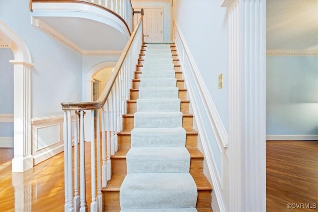 419 Dellbrooks Pl, Henrico, VA 23238 - stairway with wood finished floors, arched walkways, ornate columns, ornamental molding, and wainscoting