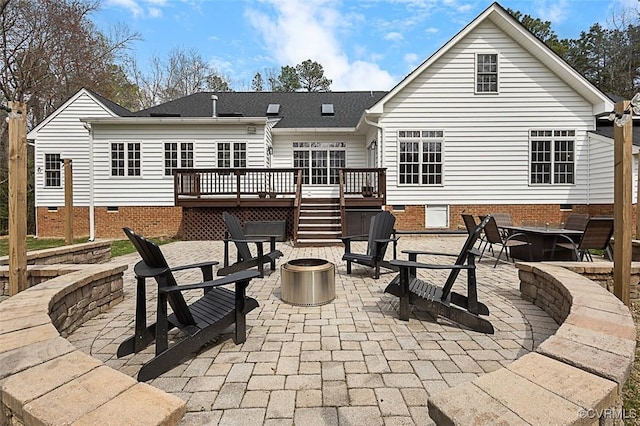 back of house with a deck, a fire pit, stairway, a patio, and crawl space