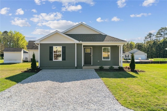 view of front facade featuring a shingled roof, covered porch, and a front yard