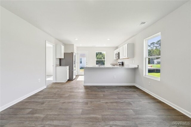 unfurnished living room with a sink, dark wood finished floors, baseboards, visible vents, and recessed lighting