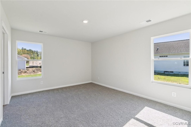 unfurnished room with baseboards, carpet flooring, visible vents, and recessed lighting