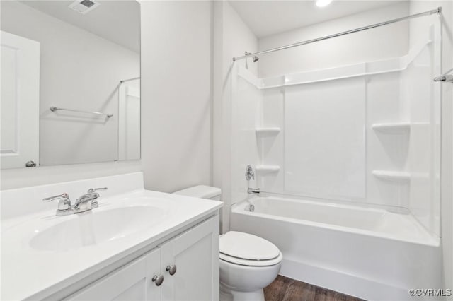 full bathroom with wood finished floors, vanity, tub / shower combination, toilet, and visible vents