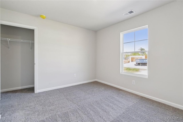 unfurnished bedroom featuring baseboards, visible vents, and carpet