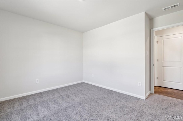 empty room featuring baseboards, visible vents, and carpet