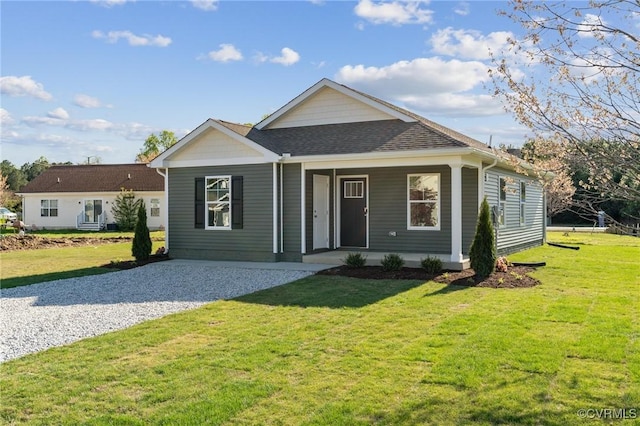 ranch-style house with roof with shingles, a porch, a front lawn, and gravel driveway