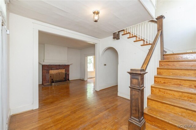 3220 Cliff Ave, Richmond, VA 23222 - stairway featuring arched walkways, wood finished floors, baseboards, and a brick fireplace