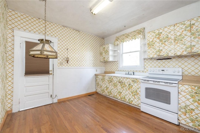 3220 Cliff Ave, Richmond, VA 23222 - kitchen with white electric range, wallpapered walls, light countertops, wood finished floors, and baseboards
