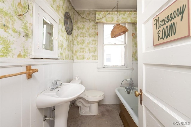 3220 Cliff Ave, Richmond, VA 23222 - bathroom featuring wallpapered walls, a tub to relax in, a wainscoted wall, and toilet