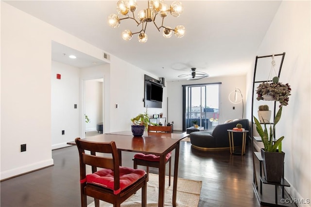 dining area featuring ceiling fan with notable chandelier, baseboards, dark wood-style floors, and visible vents