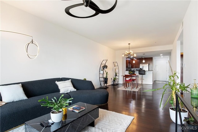 living room with a chandelier and dark wood-style flooring