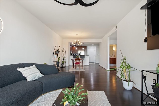 living area featuring wood finished floors, visible vents, and a notable chandelier