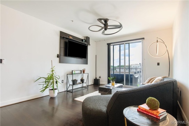 living room with ceiling fan, baseboards, and wood finished floors