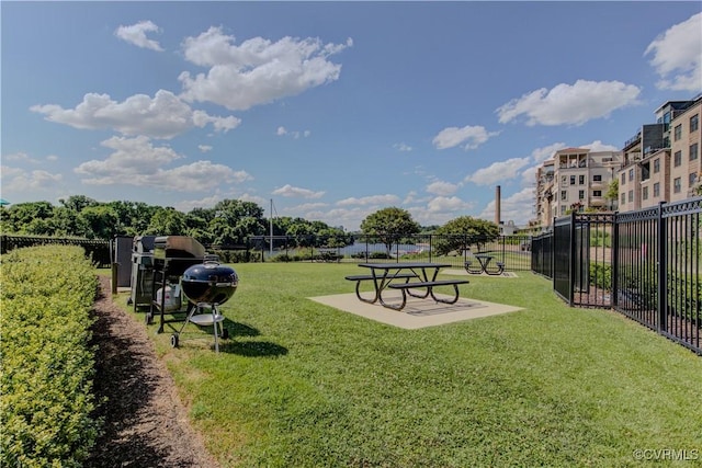 view of community featuring a lawn and fence