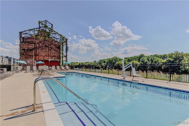 community pool with fence and a patio area