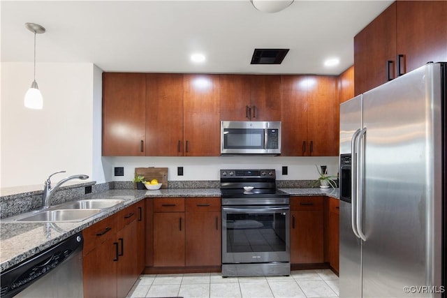 kitchen featuring stainless steel appliances, visible vents, a sink, and dark stone countertops