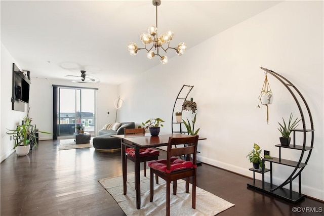 dining space with ceiling fan with notable chandelier, baseboards, and wood finished floors