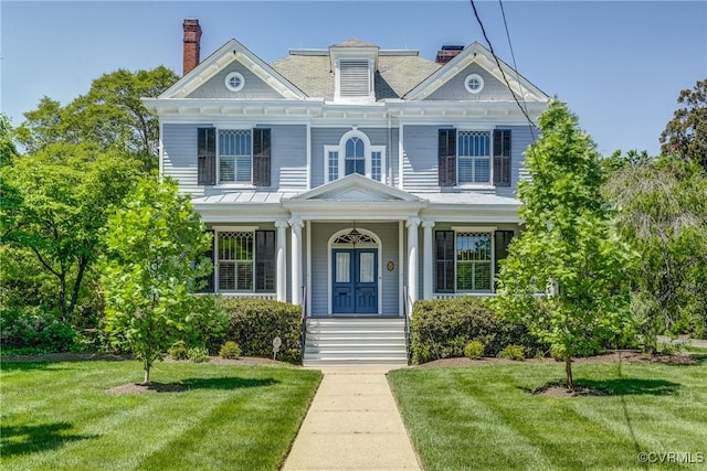 view of front of home featuring french doors, a front yard, covered porch, and a chimney