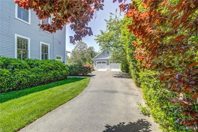 view of property exterior featuring a yard and a detached garage