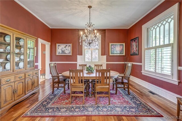 dining room with a notable chandelier, wood finished floors, and a wealth of natural light