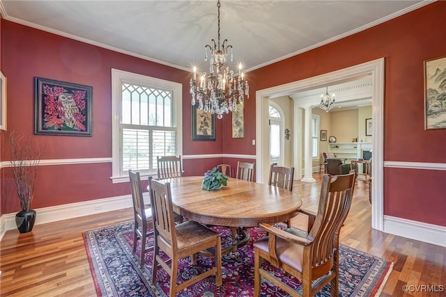 dining area with baseboards, plenty of natural light, wood finished floors, and a notable chandelier