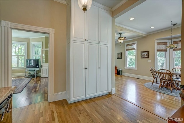 interior space with crown molding and light wood-style flooring