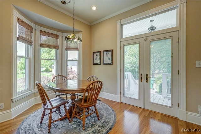 dining room with crown molding, baseboards, french doors, and light wood-type flooring