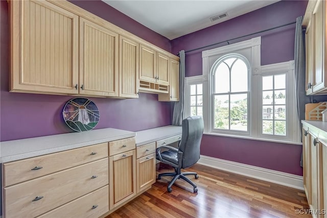 office space with plenty of natural light, baseboards, wood finished floors, and visible vents