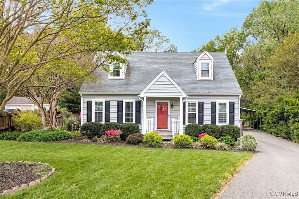 cape cod home featuring a front lawn, driveway, and a carport