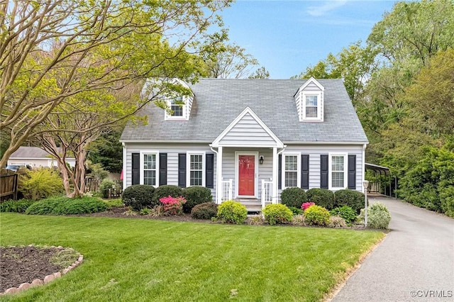 cape cod home featuring a front lawn, driveway, and a carport
