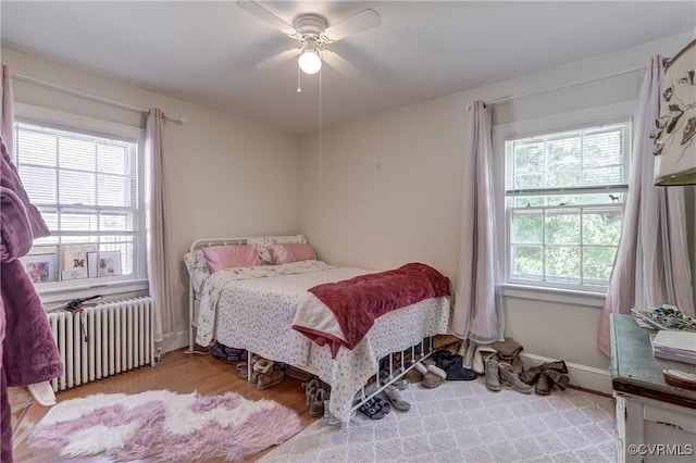 4821 W Seminary Ave, Richmond, VA 23227 - bedroom with radiator, a ceiling fan, and wood finished floors