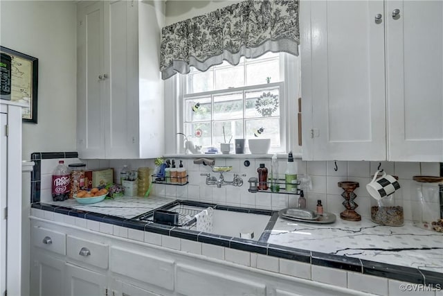 4821 W Seminary Ave, Richmond, VA 23227 - kitchen featuring a sink, white cabinets, and decorative backsplash