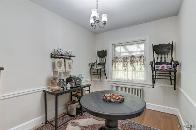 4821 W Seminary Ave, Richmond, VA 23227 - dining space featuring radiator heating unit, wood finished floors, a notable chandelier, and baseboards