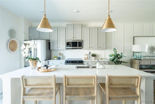 507 Golden Haze Aly Unit 17-1, Midlothian, VA 23113 - kitchen with stainless steel appliances, light countertops, tasteful backsplash, a center island with sink, and hanging light fixtures