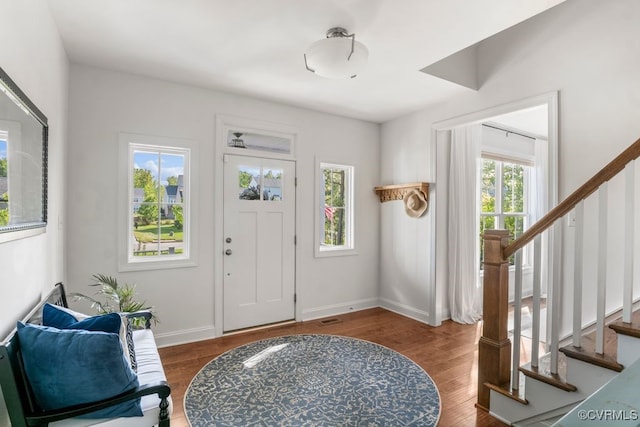 entrance foyer featuring baseboards, stairs, and wood finished floors