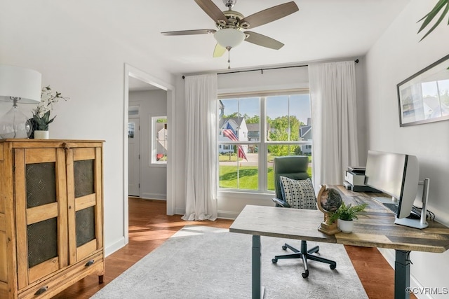 office space featuring baseboards, a ceiling fan, and dark wood-style floors