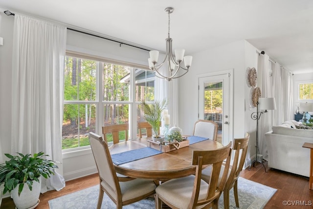 dining space with an inviting chandelier and wood finished floors