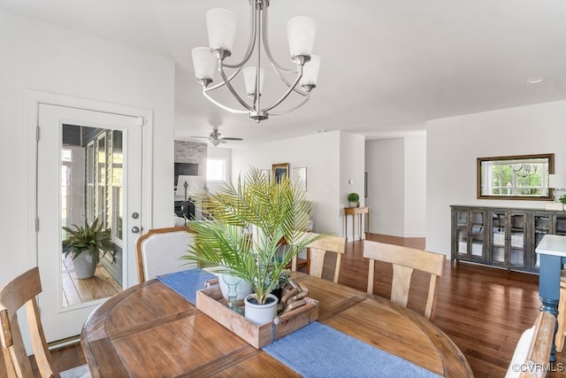 dining area featuring ceiling fan with notable chandelier and wood finished floors