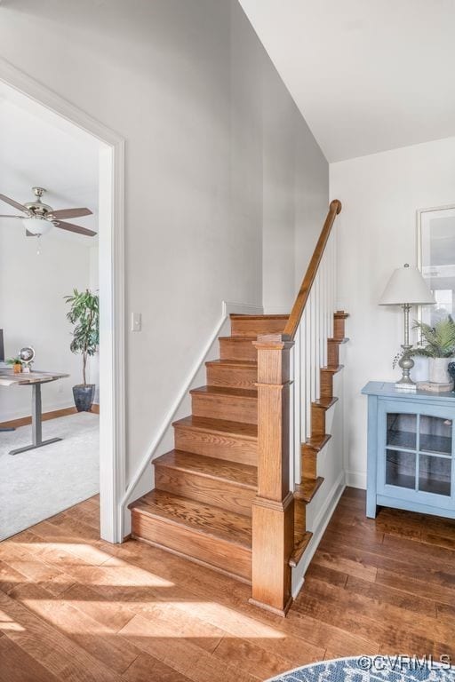stairs with baseboards, a ceiling fan, and wood finished floors
