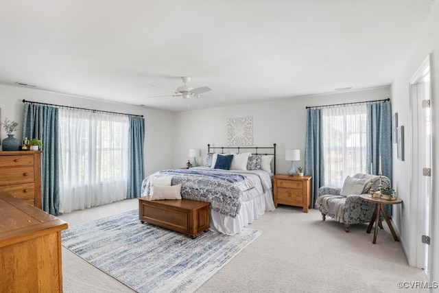 bedroom featuring light colored carpet, a ceiling fan, and visible vents