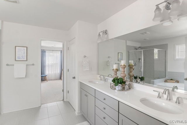 full bath with double vanity, a sink, tile patterned floors, and a shower stall