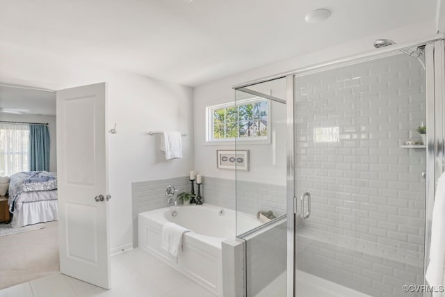 bathroom featuring tile patterned flooring, ensuite bath, baseboards, a shower stall, and a garden tub