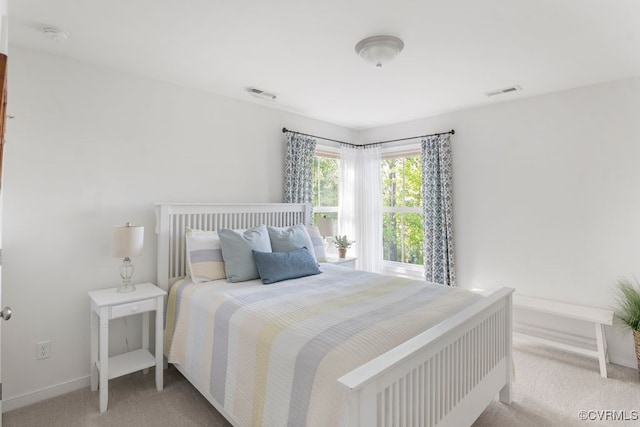 bedroom with baseboards, light carpet, and visible vents
