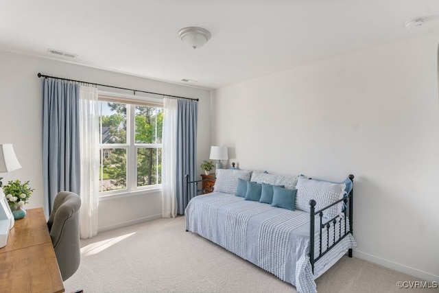 bedroom featuring baseboards, visible vents, and light carpet