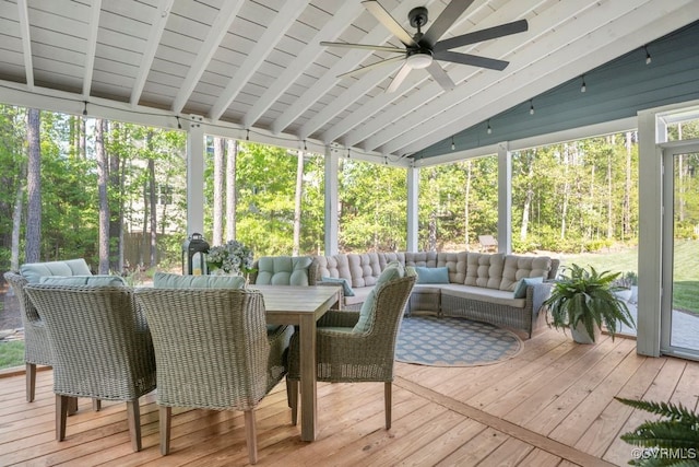 sunroom with a ceiling fan, outdoor dining space, an outdoor living space, and beam ceiling