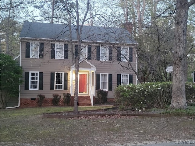 colonial inspired home with a chimney and crawl space